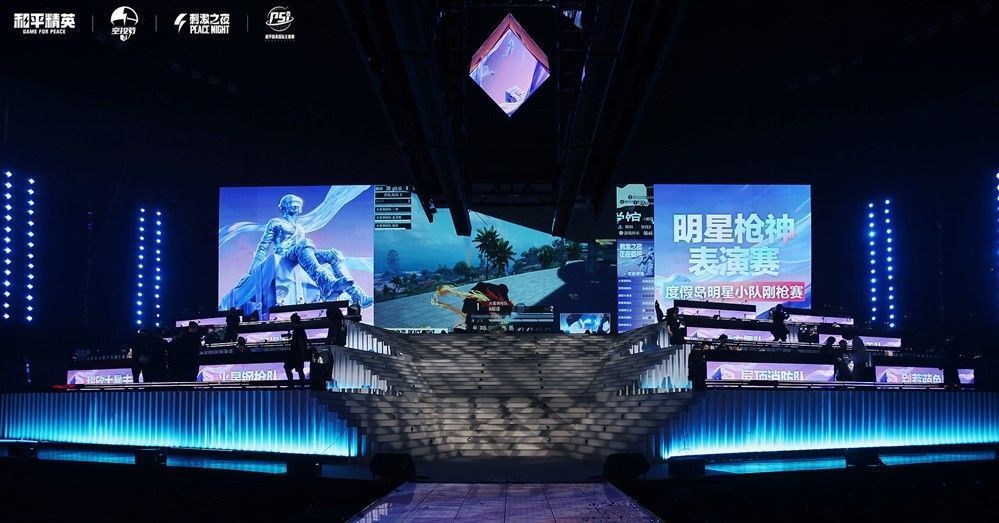 多位明星佩戴电竞耳机坐在比赛区，面前屏幕显示游戏对战画面，现场观众欢呼