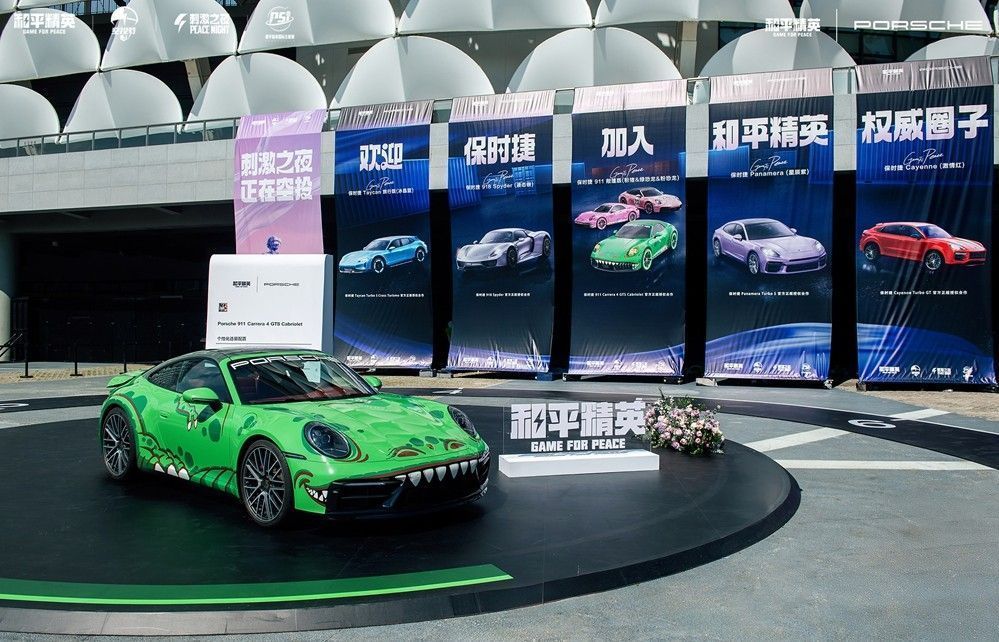 保时捷展区陈列经典车型，COSER与游客互动拍照，车身为‘绿恐龙’主题涂装