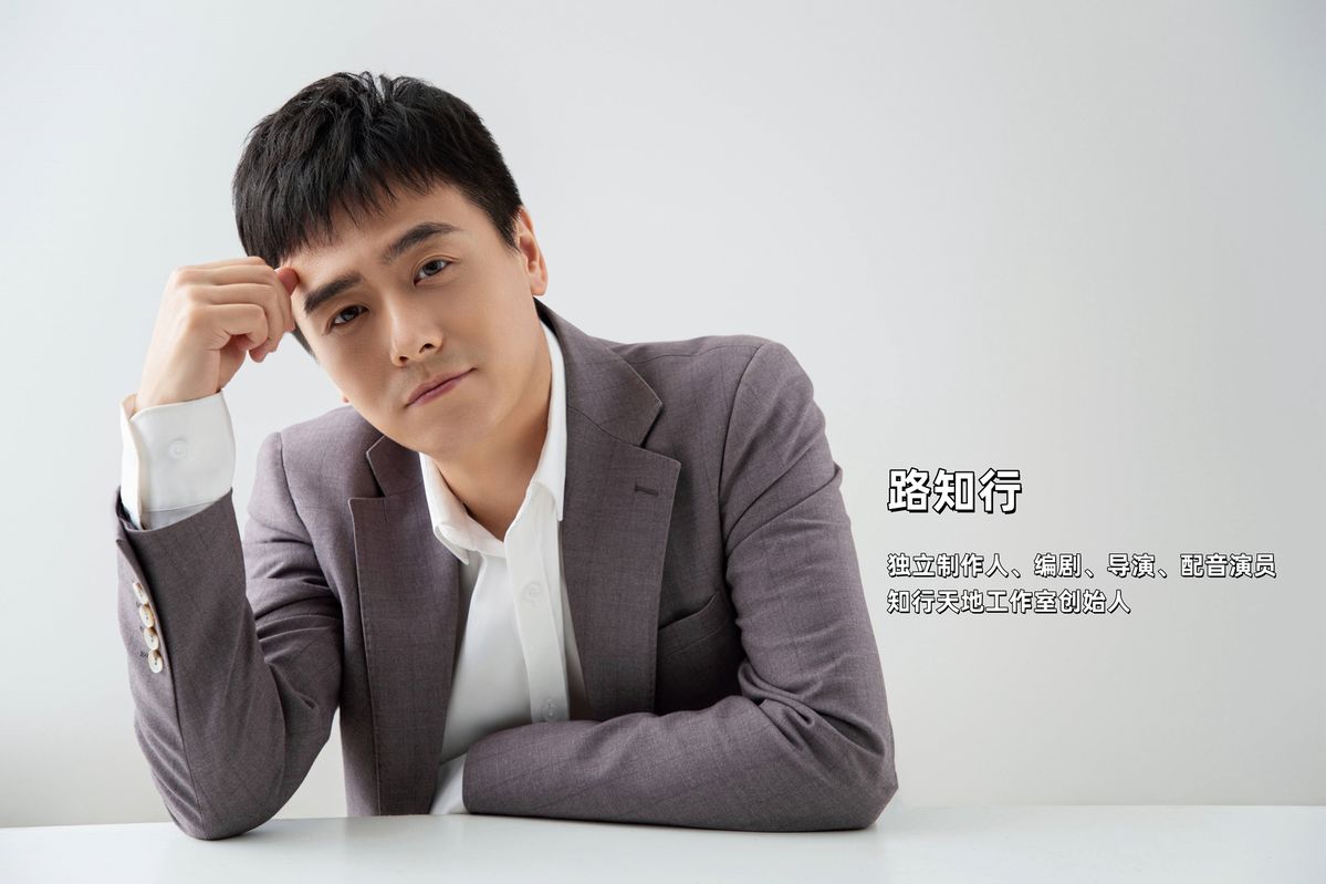 配音导演路知行工作照，神情专注地对着麦克风进行录音，背景为专业录音棚环境