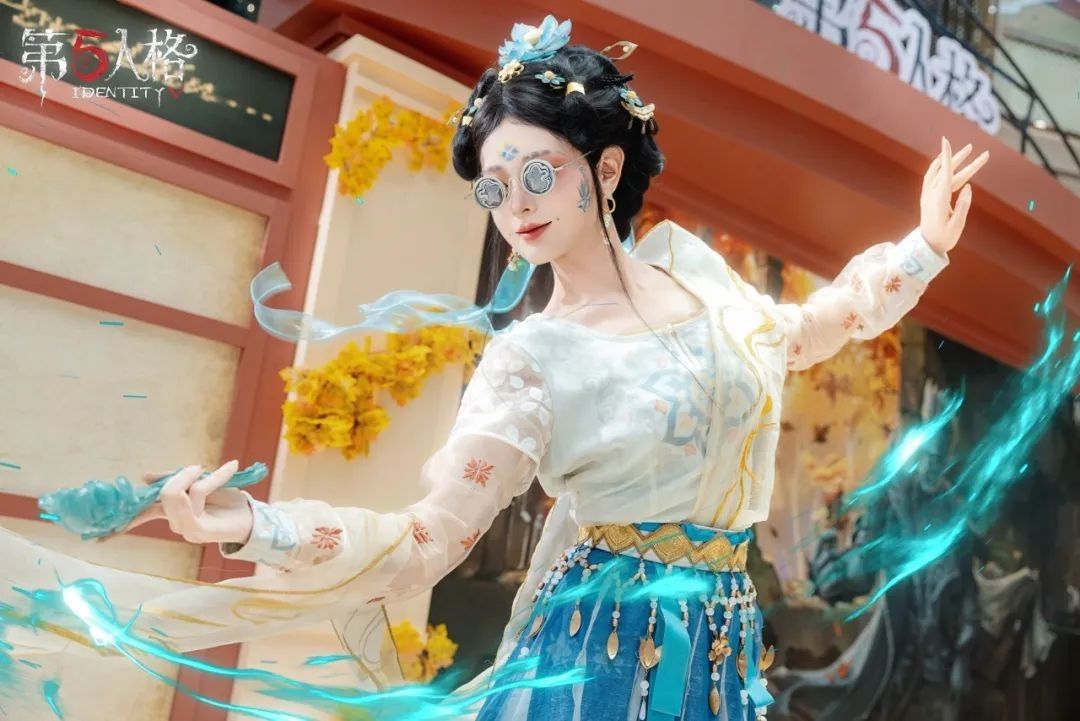 医生COSER站在秋日主题布景前微笑挥手，身后是金黄落叶装饰