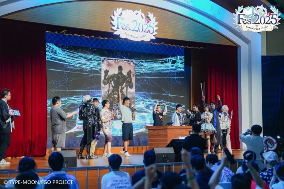 三位声优站在舞台上向观众挥手致意，背景为FGO九周年LOGO