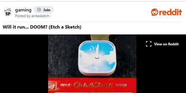 玩家手持Etch A Sketch展示完整画面，屏幕中清晰可见《毁灭战士》主角持枪对战恶魔的构图