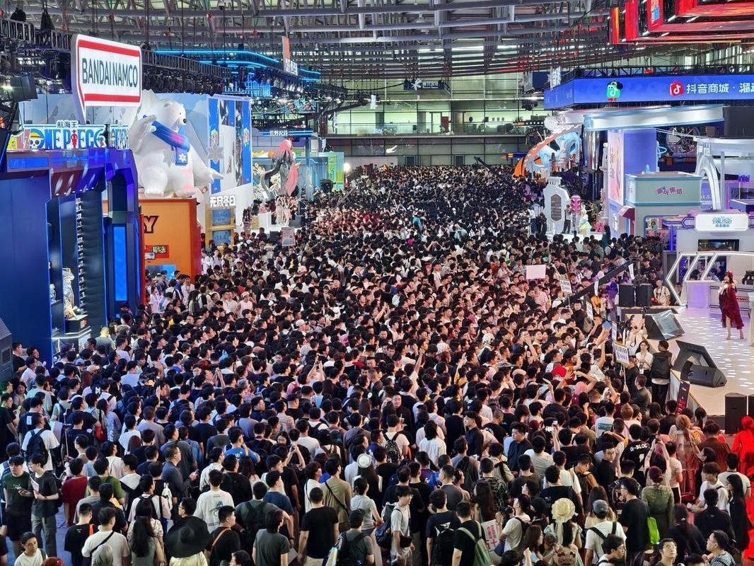 展区内部细节展示，不同游戏区域色彩分明，玩家正在试玩游戏