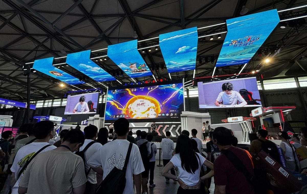 《航海王：壮志雄心》舞台表演赛现场，选手专注对战，背景为巨型路飞形象