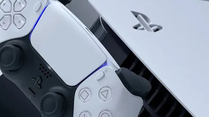 索尼PS5主机陈列展示，背景为PlayStation品牌标识与多款热门游戏封面