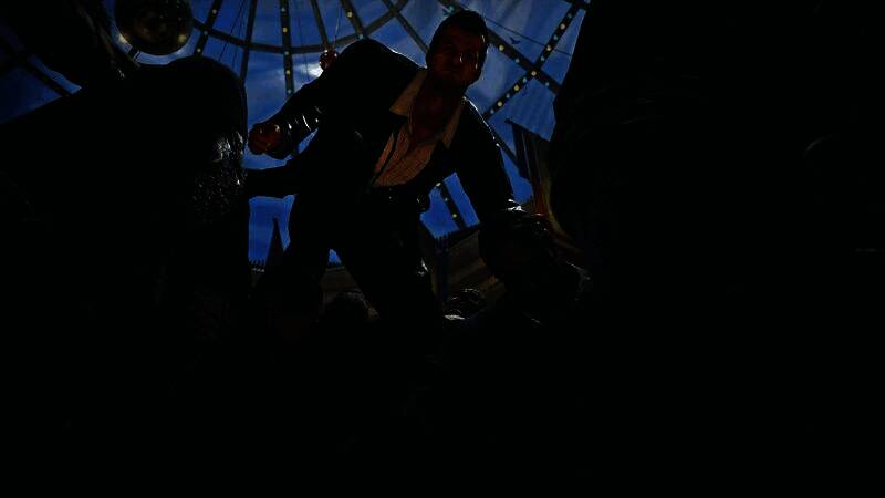 《丧尸围城豪华：复刻版》游戏封面展示，主角弗兰克·韦斯特手持相机与武器，背景为被丧尸包围的城市街道