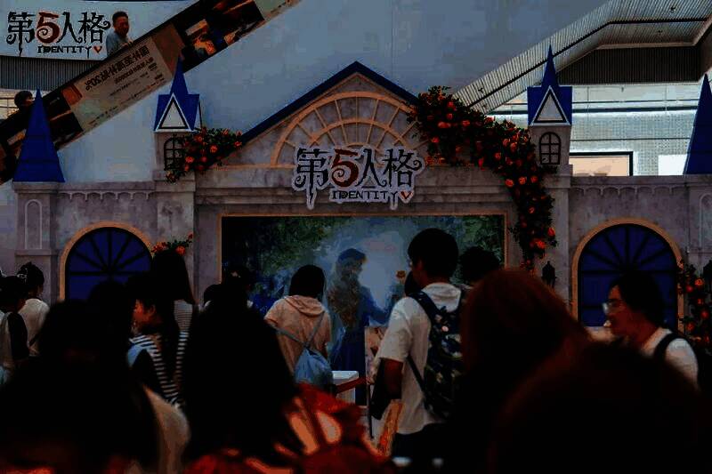 玩家正在参与‘骰子比拼’游戏，桌上摆放着《第五人格》主题骰子，工作人员在一旁计分