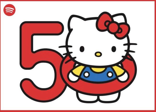 凯蒂猫50周年纪念展入口现场图，展板上印有巨大的凯蒂猫形象和‘50th Anniversary’字样，周围布置着粉色气球与彩带