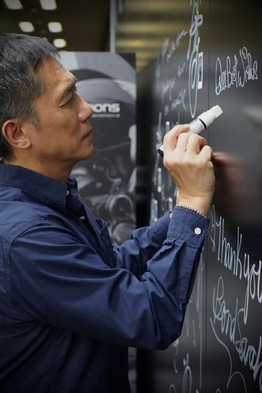 小岛秀夫手持相机拍摄梁朝伟，展现双方友好互动