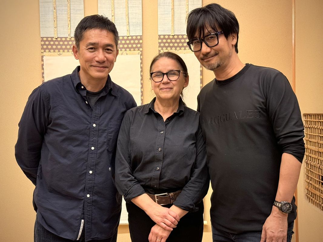 工作室内部合影，墙上挂着《死亡搁浅》系列概念图