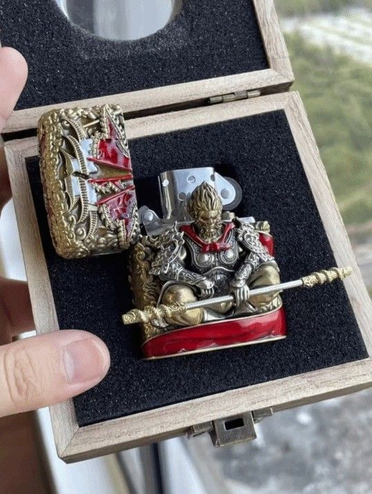 打火机侧面展示，清晰可见祥云纹路与游戏LOGO雕刻