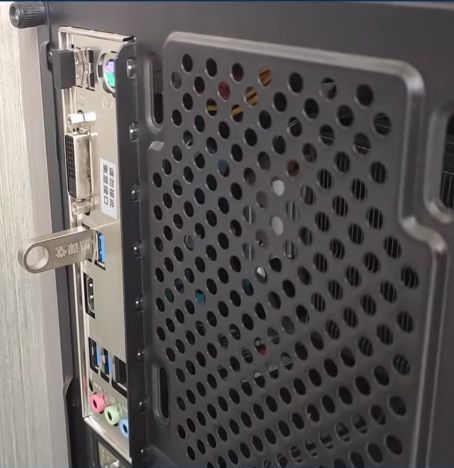 U盘插入电脑的示意图，显示USB接口与电脑主机连接