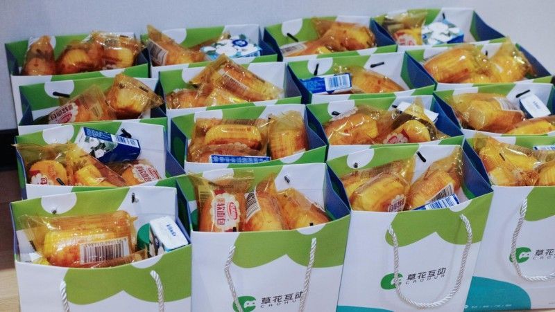 工作人员为抵达的玩家发放贴心接机礼包，内含零食与旅途必需品