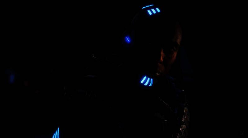 兰斯·莱迪克在《地平线》系列中饰演赛伦斯的剧照，角色神情严肃，背景为游戏场景