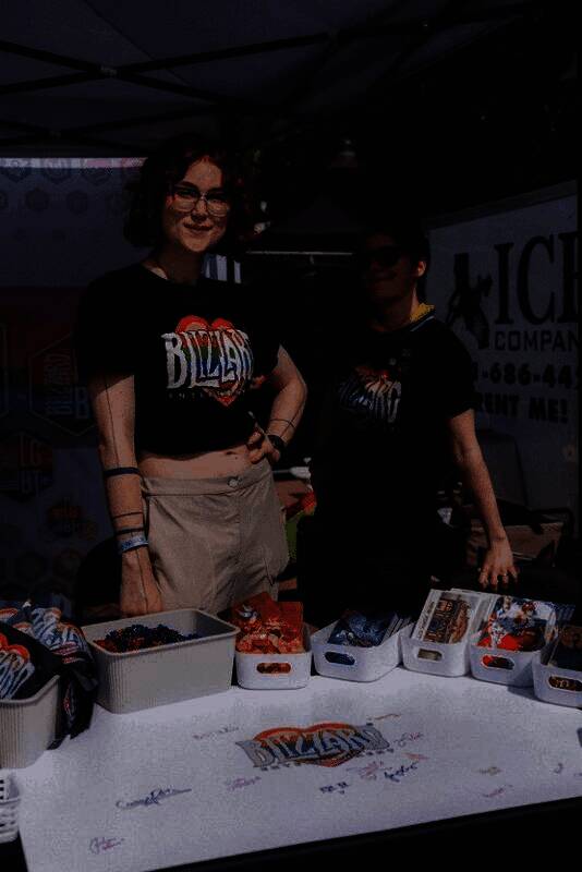 游行现场众人合影留念，背景是象征多元与包容的彩虹旗帜