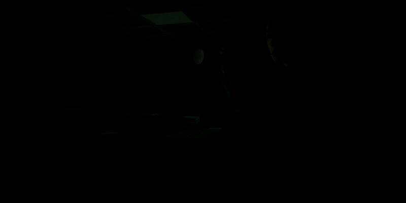 《心灵杀手2》Lake House DLC宣传图，展示主角Kiran Estevez在湖边小屋前的紧张对峙场景