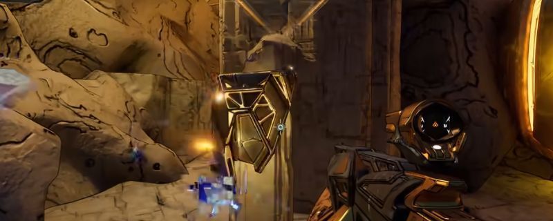 《无主之地4》游戏中废弃哨站左侧海岸线场景，玩家角色正靠近一处岩石缝隙，手中拾取发光的秘藏钥匙