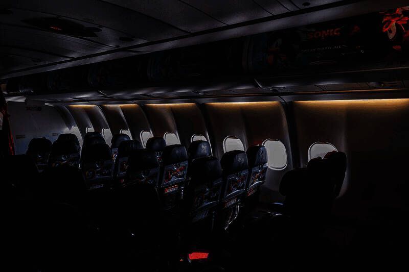 桌面上摆放着亚航与索尼克联名纪念品套装，包含钥匙扣、卡片和特别版登机牌