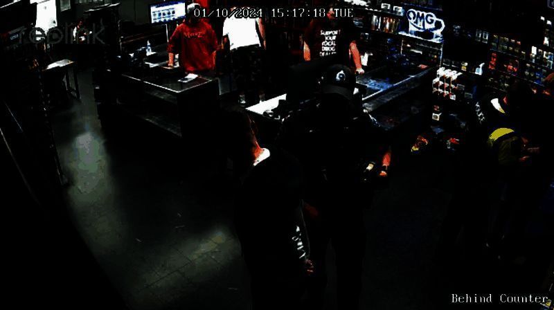 警方在桌游店内带走两名嫌疑男子，周围有警察和店员注视