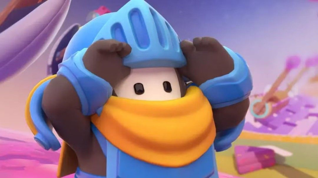 《糖豆人》游戏中一群彩色小豆人奔跑在巨大障碍赛道上，背景充满卡通风格的滑梯和滚筒机关