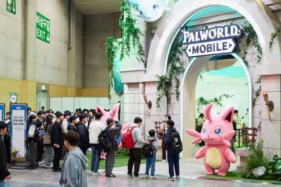 Yoon Jjukku团队与帕鲁人偶在展台上进行游行表演，周围观众热情鼓掌