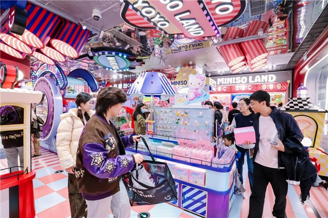 商场内部人潮涌动，顾客在MINISO LAND门店前排队入场，背景可见巨型IP展陈装置