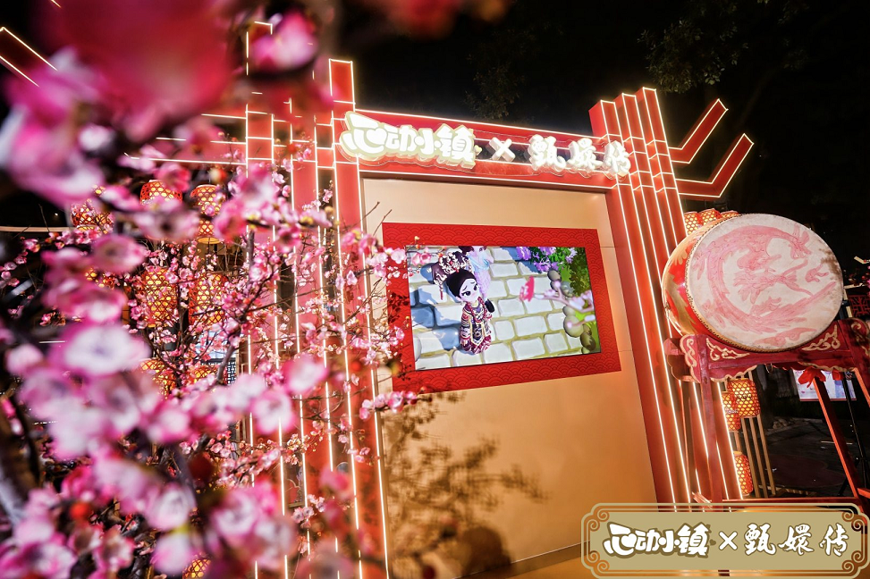 夜晚灯光下的活动现场，古风灯笼照亮街道，玩家们手持联动礼品与NPC合影，笑容洋溢