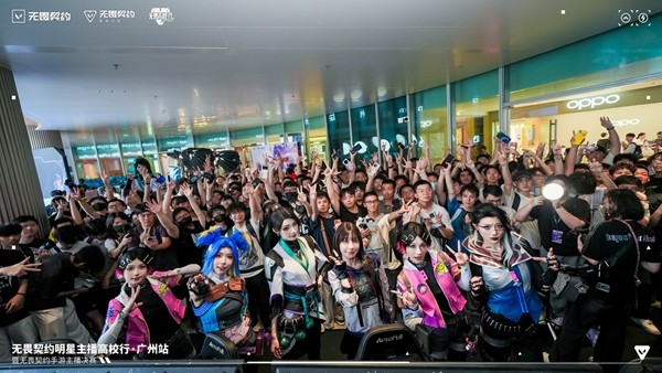 活动现场玩家聚集在《无畏契约》主题展区前拍照打卡，背景充满赛博霓虹风格的美术设计