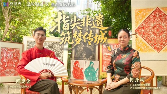 剪纸艺术家何丹凤手持作品现场创作，桌上散落着红纸碎片与未完成的飞鸟图案