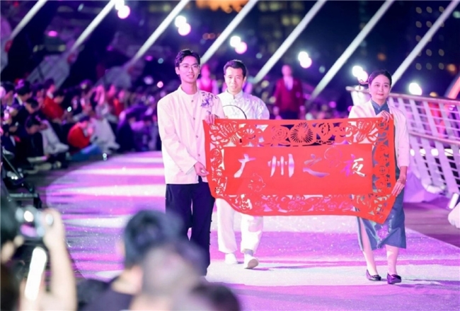 何丹凤在广马博览会现场向观众介绍剪纸文化，展台布置充满岭南风情