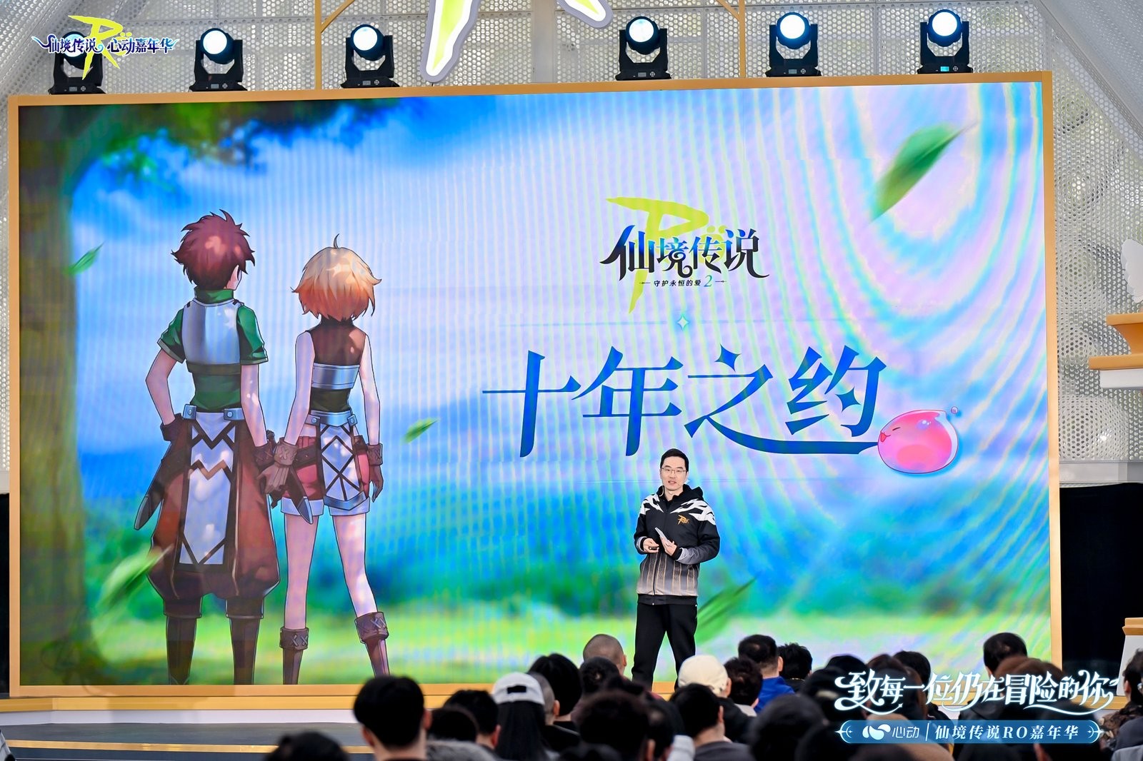 上海鲁迅公园微风礼堂外景，巨型RO主题拱门与飘扬的守爱旗帜交相辉映，现场人潮涌动，充满庆典氛围