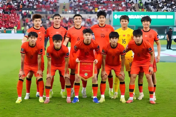 《FC足球梦剧场》游戏主视觉图：晨光中的绿茵场中央矗立着一座融合中式牌坊与现代训练塔的青训基地，背景浮现‘街超’‘村超’字样与跃动的少年剪影