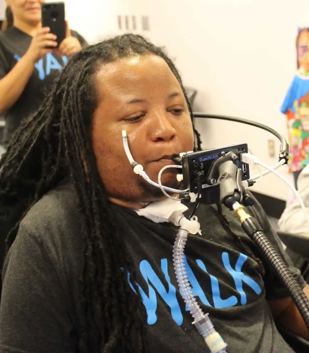 QuadStick控制器实物特写：紧凑型黑色主机连接四路呼吸传感器与口腔压力感应模块，表面印有无障碍认证标识